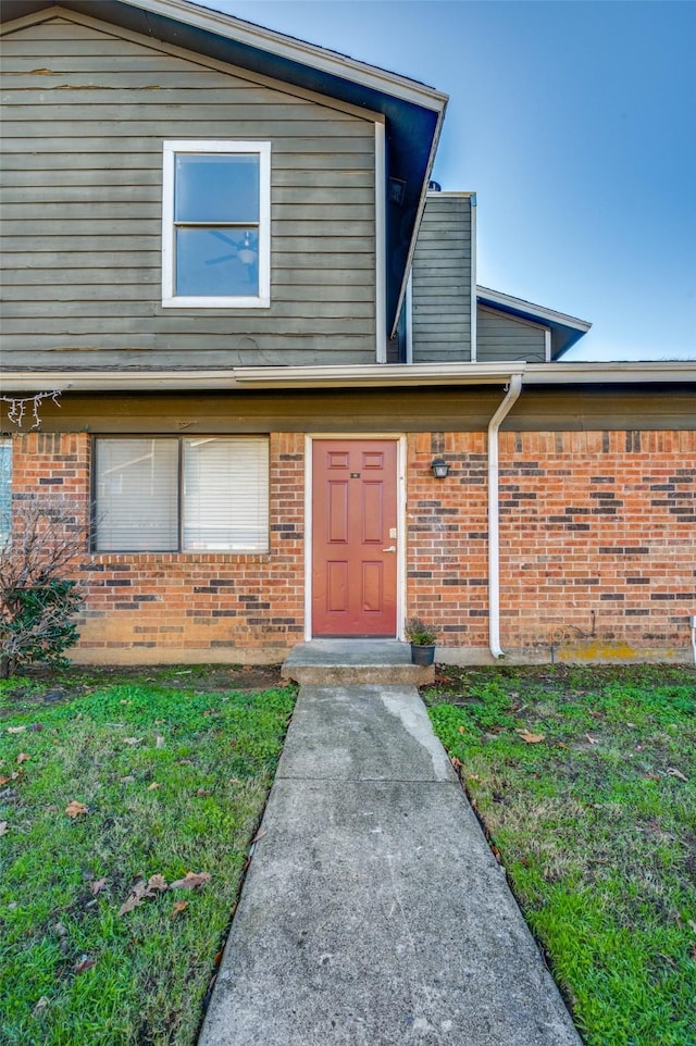 property entrance with a lawn