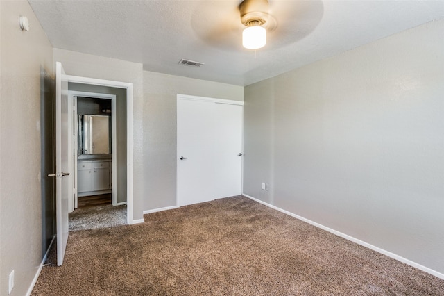 unfurnished bedroom featuring ceiling fan and dark colored carpet