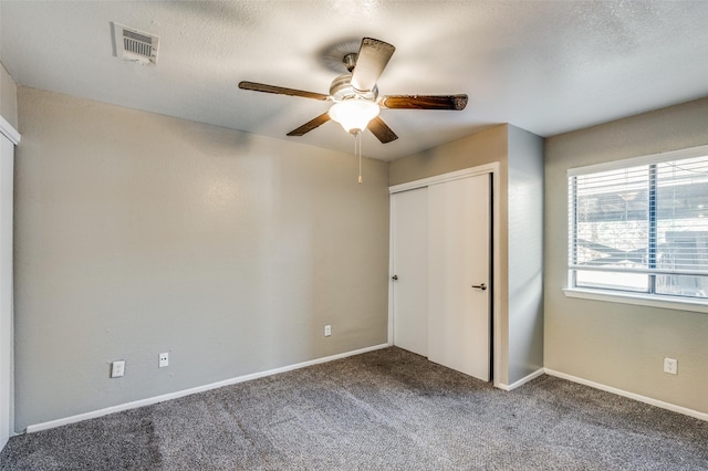 unfurnished bedroom with ceiling fan, a closet, and carpet floors