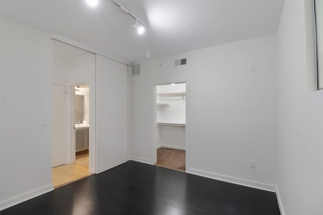 unfurnished room with rail lighting and hardwood / wood-style flooring