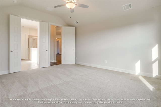 unfurnished bedroom featuring ceiling fan, light carpet, visible vents, baseboards, and vaulted ceiling