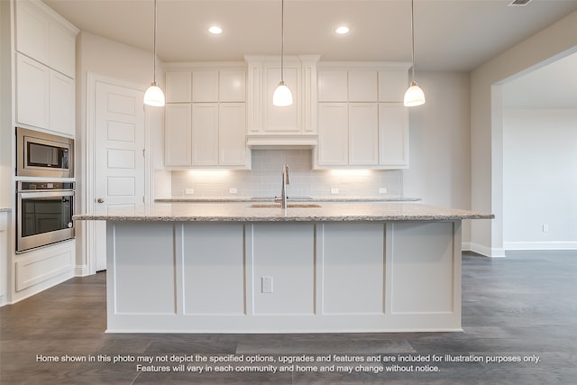 kitchen with appliances with stainless steel finishes, a sink, a center island with sink, and white cabinets