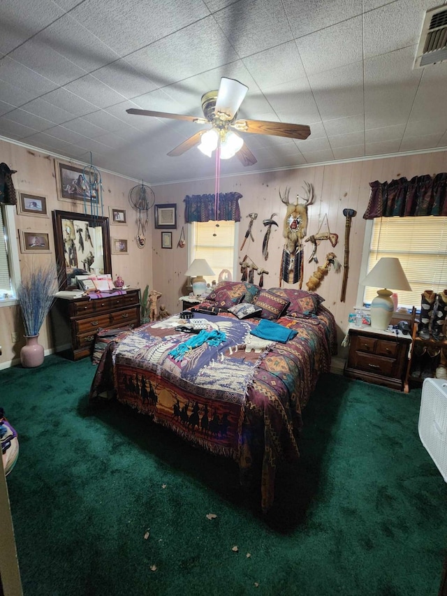 carpeted bedroom with ceiling fan and wooden walls