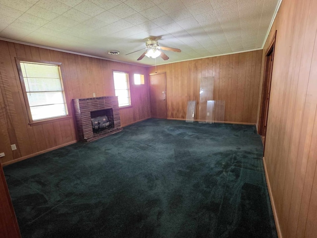 unfurnished living room with carpet flooring, visible vents, wooden walls, and ceiling fan