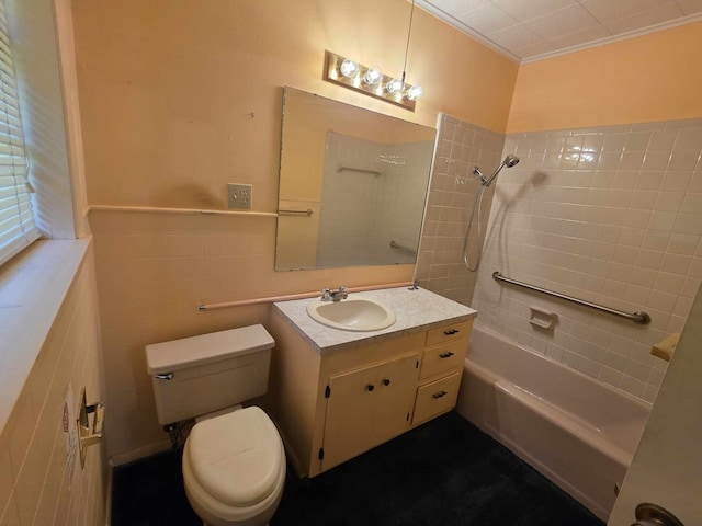 full bathroom featuring vanity, toilet, shower / bath combination, wainscoting, and tile walls