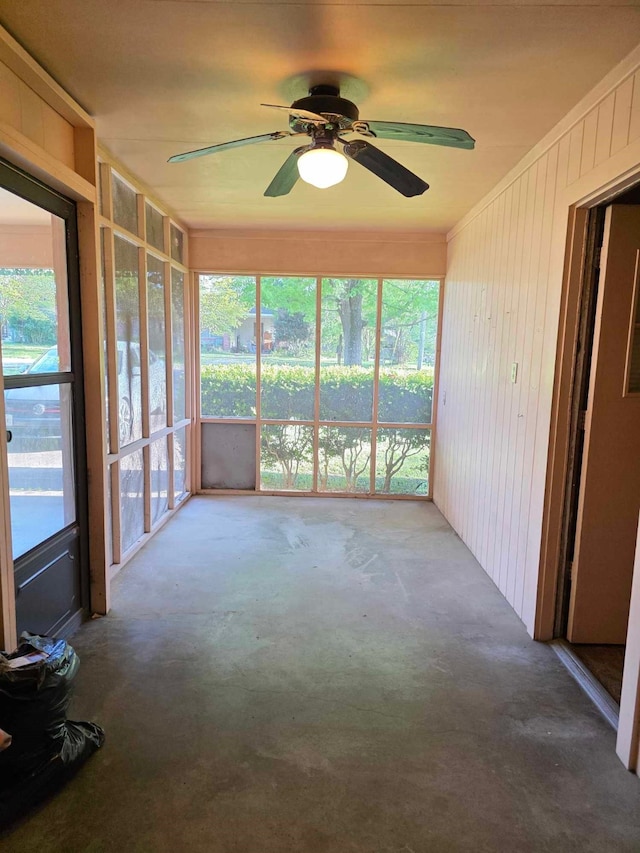 unfurnished sunroom featuring ceiling fan