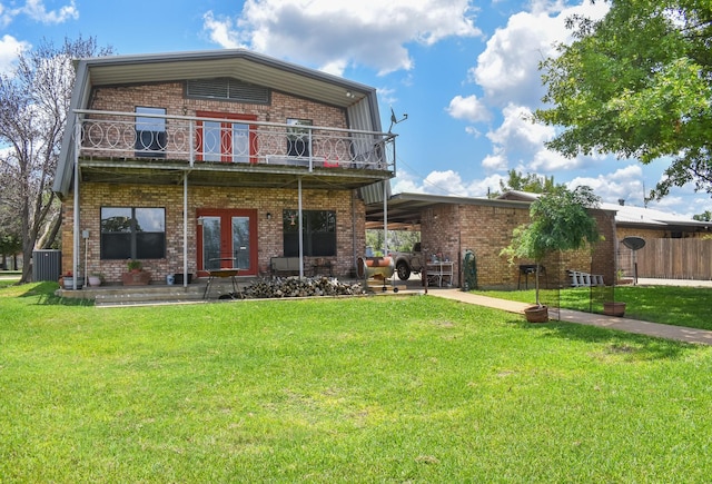 back of house with a patio area, a yard, and french doors