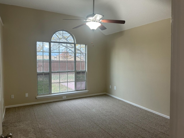 carpeted empty room featuring ceiling fan and vaulted ceiling