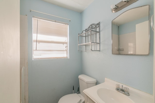 bathroom with a shower, vanity, and toilet