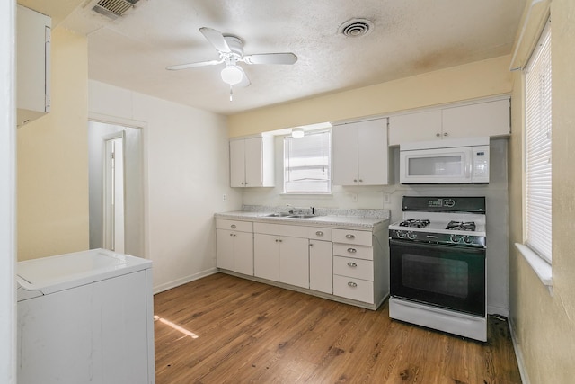 kitchen with white cabinets, sink, ceiling fan, light wood-type flooring, and range with gas stovetop