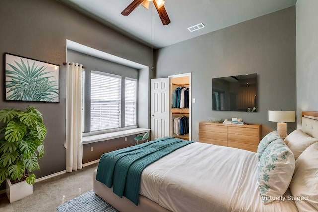 bedroom with ceiling fan, a spacious closet, carpet floors, and a closet