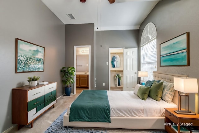 carpeted bedroom featuring a walk in closet, ceiling fan, and ensuite bathroom