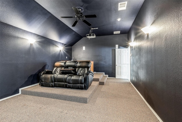 carpeted cinema with ceiling fan and vaulted ceiling