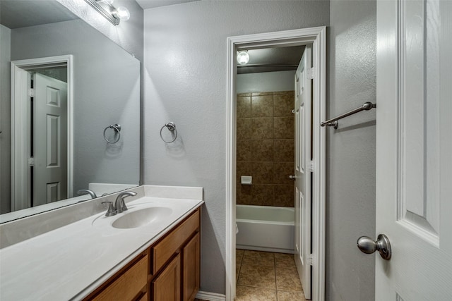 full bathroom featuring tile patterned flooring, vanity, tiled shower / bath combo, and toilet