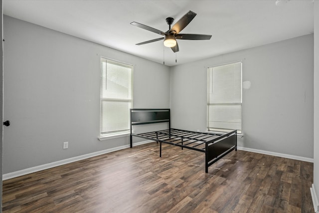 bedroom with dark hardwood / wood-style flooring and ceiling fan