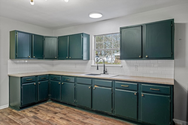 kitchen featuring green cabinets, wood-type flooring, and sink