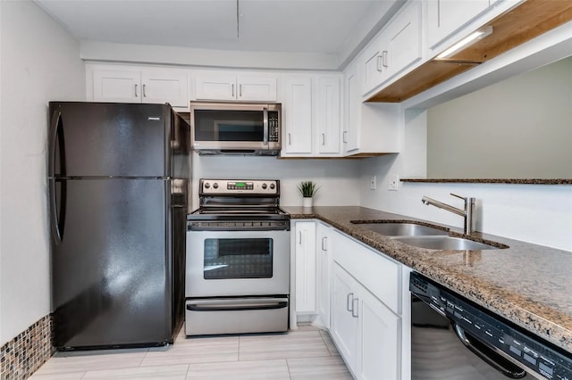 kitchen with white cabinetry, sink, dark stone counters, and black appliances