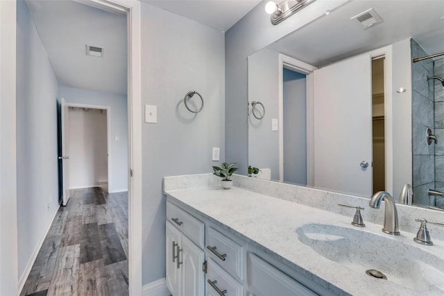 bathroom featuring hardwood / wood-style flooring, walk in shower, and vanity