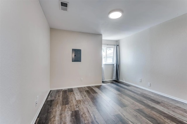 spare room featuring dark wood-type flooring and electric panel