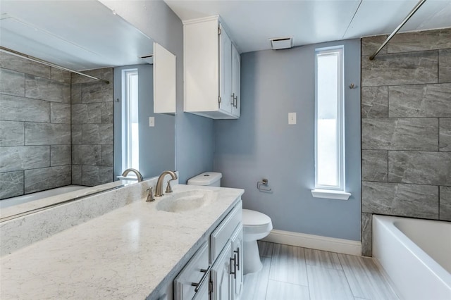 full bathroom with toilet, vanity, and tiled shower / bath combo