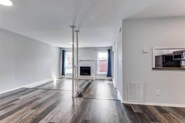 unfurnished living room with dark wood-type flooring