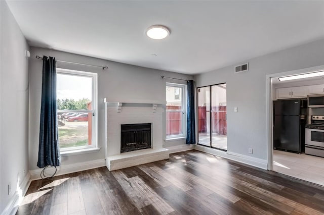 unfurnished living room featuring hardwood / wood-style flooring, a fireplace, and plenty of natural light