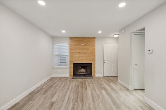 unfurnished living room featuring a fireplace and light hardwood / wood-style flooring