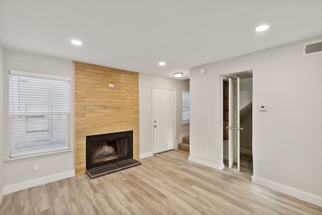 unfurnished living room featuring a fireplace and light hardwood / wood-style flooring