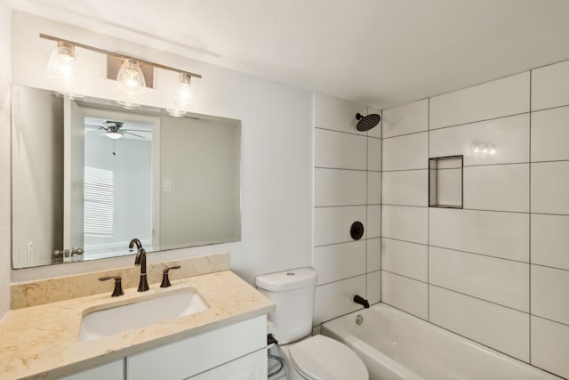 full bathroom featuring vanity, toilet, tiled shower / bath, and ceiling fan