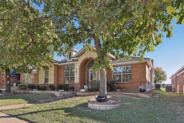 view of front of property with a front yard and central AC