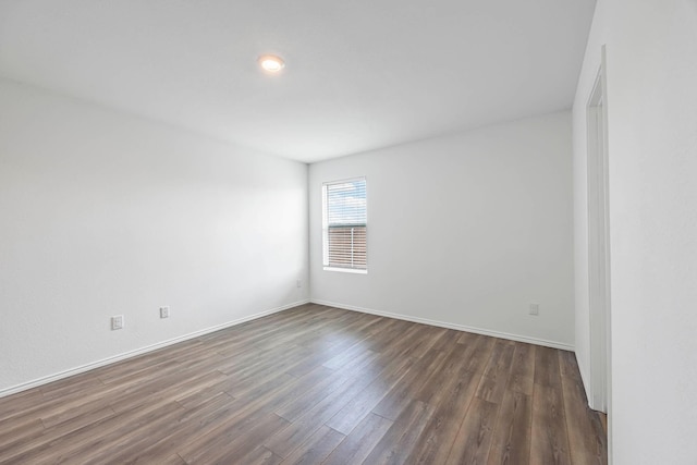 spare room featuring dark wood-type flooring