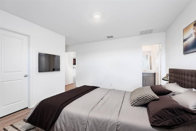 bedroom featuring ensuite bathroom and light hardwood / wood-style floors