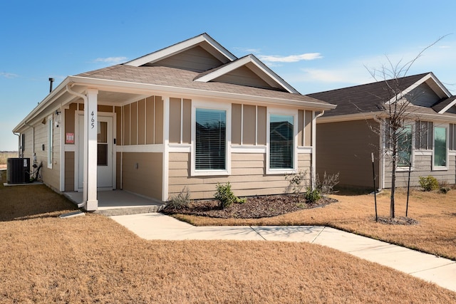 view of front facade with a front lawn and central air condition unit