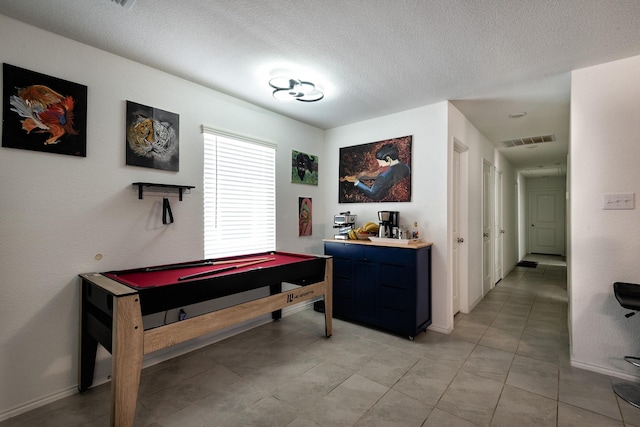 playroom with pool table and a textured ceiling