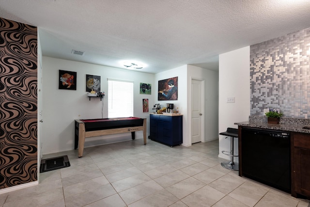 interior space with a textured ceiling and light tile patterned floors