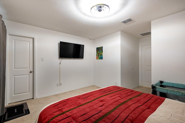 bedroom featuring light carpet and a textured ceiling