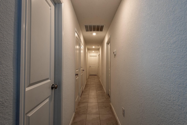 hall with light tile patterned floors