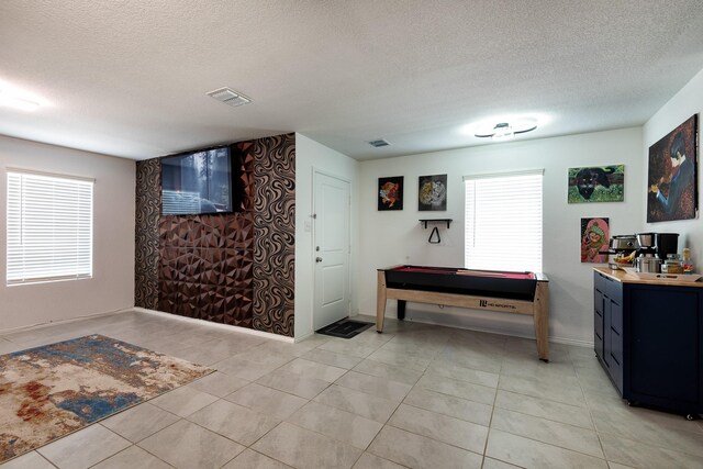 interior space featuring tile patterned flooring, vanity, pool table, and a textured ceiling