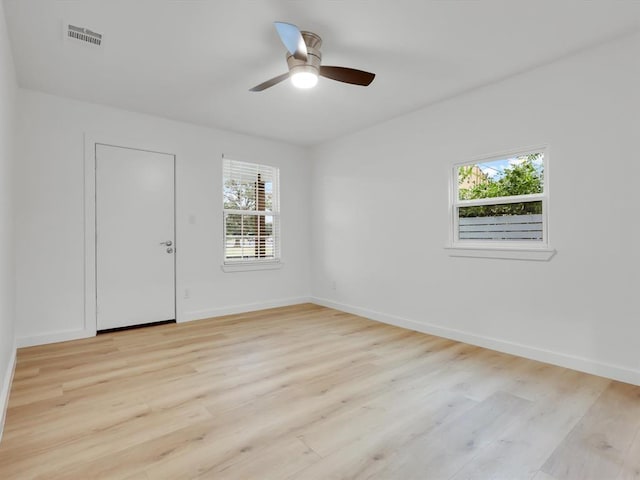 empty room with ceiling fan and light hardwood / wood-style flooring