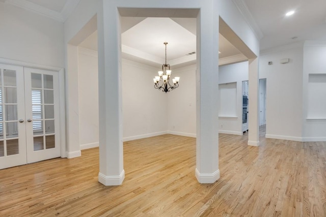 interior space with light hardwood / wood-style flooring, ornamental molding, french doors, and a notable chandelier