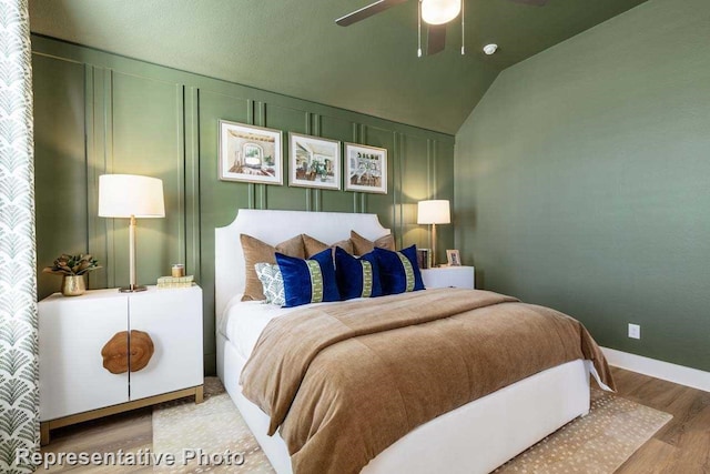 bedroom featuring ceiling fan, wood-type flooring, and vaulted ceiling