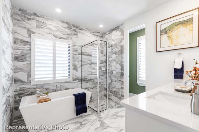 bathroom featuring shower with separate bathtub, vanity, and a wealth of natural light