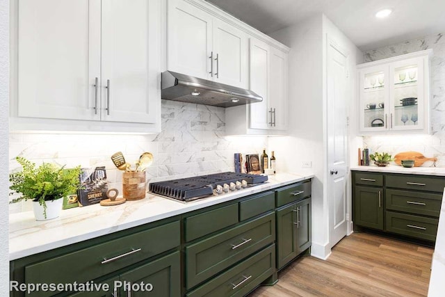 kitchen with stainless steel gas stovetop, white cabinetry, and backsplash