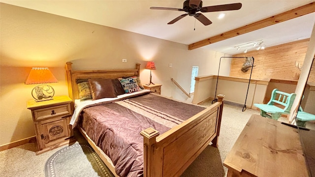 carpeted bedroom featuring beam ceiling and ceiling fan