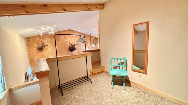 hall featuring light hardwood / wood-style floors, lofted ceiling, and wood walls