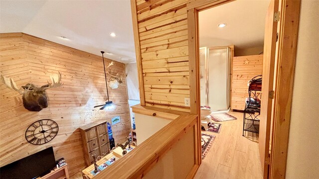 bathroom featuring wooden walls, vanity, and walk in shower