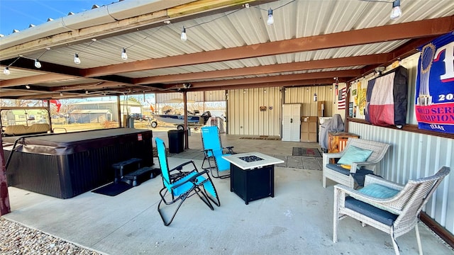 view of patio / terrace featuring an outdoor fire pit and a hot tub