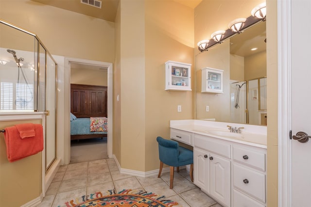 full bath with visible vents, a stall shower, vanity, baseboards, and tile patterned floors