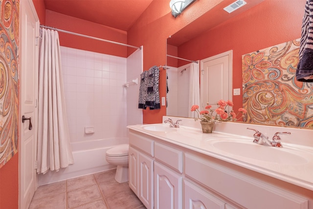 bathroom featuring double vanity, a sink, visible vents, and tile patterned floors