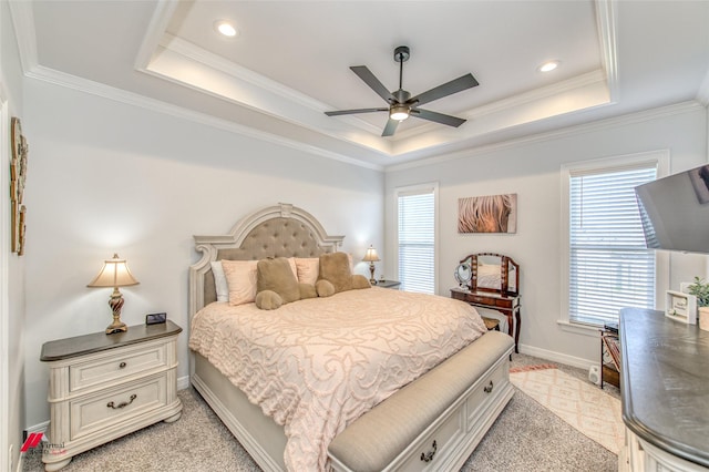 bedroom with ceiling fan, ornamental molding, multiple windows, and a tray ceiling